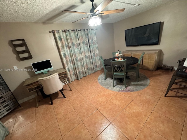 dining space featuring ceiling fan, light tile patterned floors, and a textured ceiling