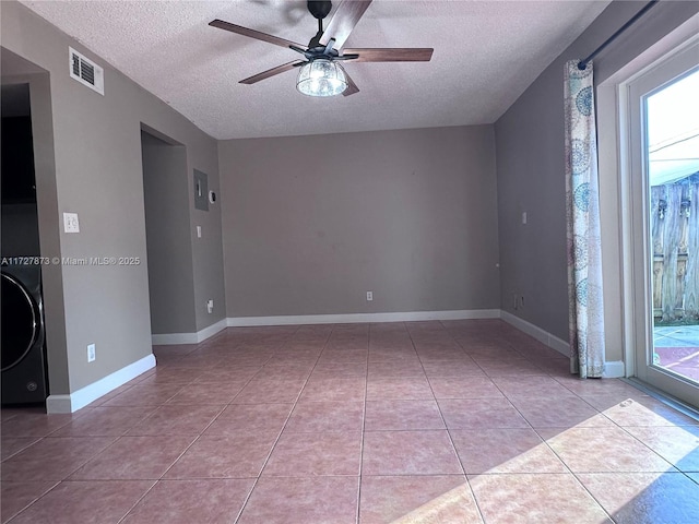 unfurnished room with ceiling fan, a textured ceiling, light tile patterned floors, and washer / dryer