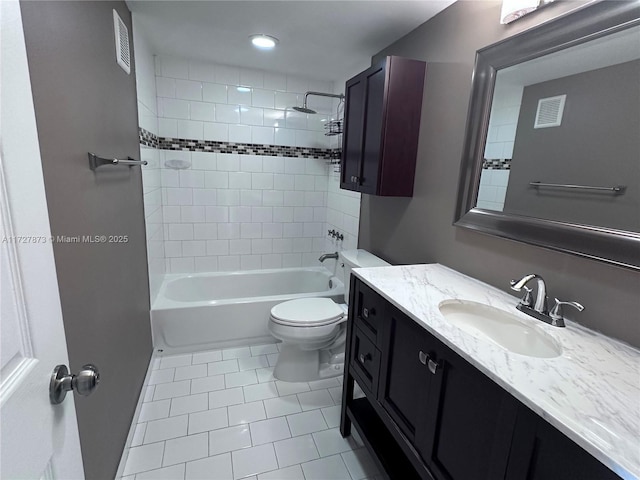 full bathroom featuring toilet, vanity, tile patterned flooring, and tiled shower / bath combo