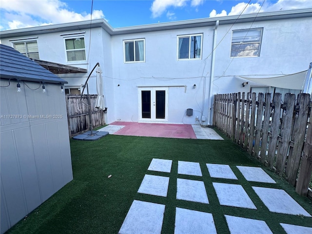 back of house with a yard, french doors, and a patio