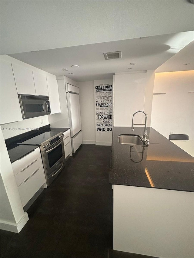 kitchen with sink, white cabinets, and appliances with stainless steel finishes