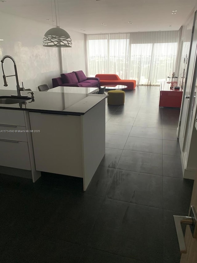 tiled living room featuring plenty of natural light and sink