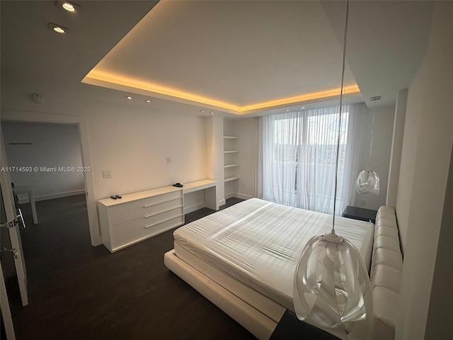 bedroom featuring dark hardwood / wood-style flooring and a tray ceiling