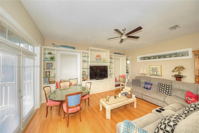 living room with light wood-type flooring and ceiling fan