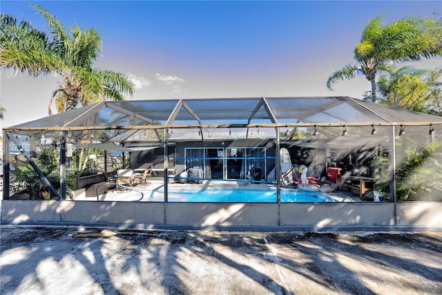 view of swimming pool with a patio and glass enclosure