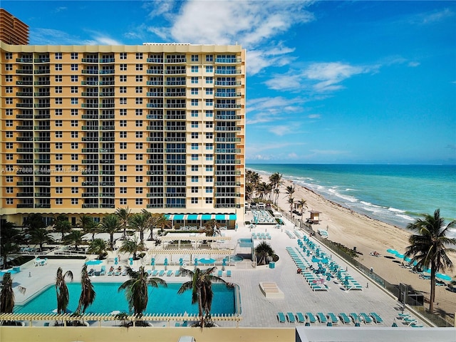 view of building exterior with a water view and a beach view