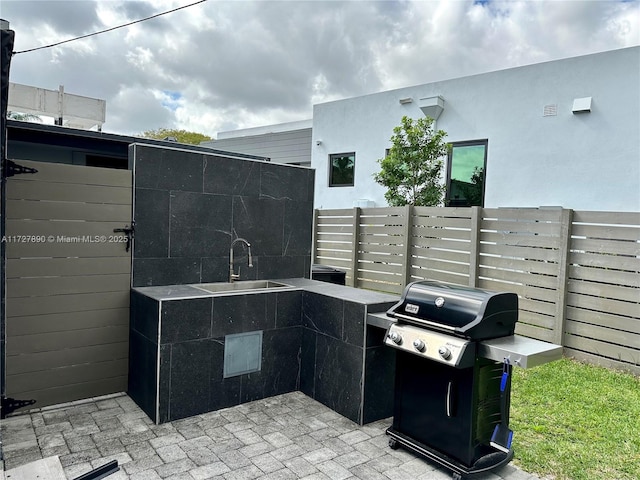 view of patio / terrace featuring a grill and sink