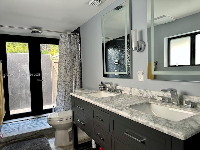 bathroom with french doors, vanity, curtained shower, and toilet