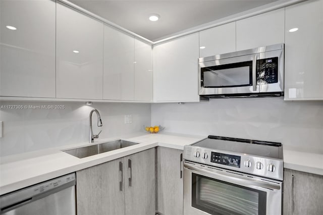 kitchen featuring backsplash, appliances with stainless steel finishes, sink, and white cabinets