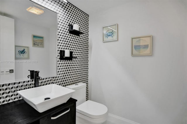 bathroom featuring tile walls, vanity, and toilet