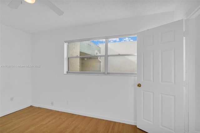 empty room featuring a textured ceiling, ceiling fan, and wood-type flooring