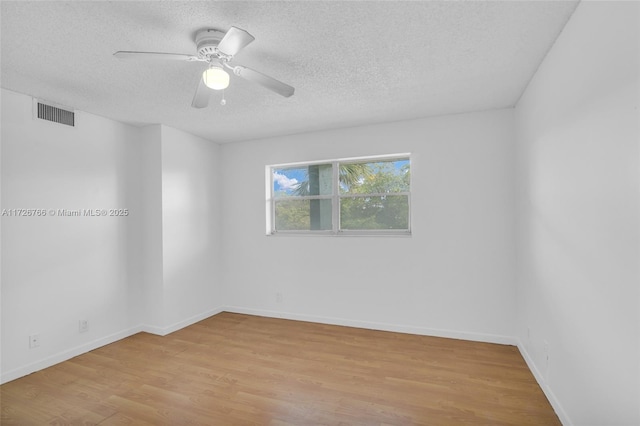 empty room with a textured ceiling, ceiling fan, and light hardwood / wood-style floors