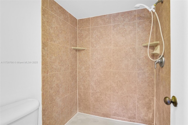 bathroom with toilet and a tile shower