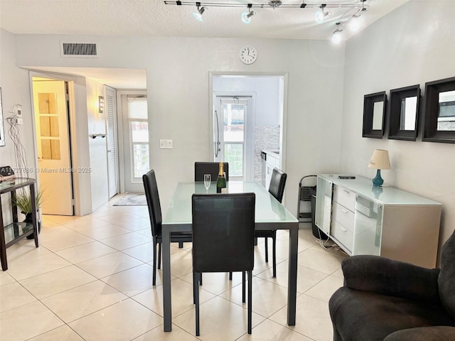 dining room featuring light tile patterned flooring and a textured ceiling