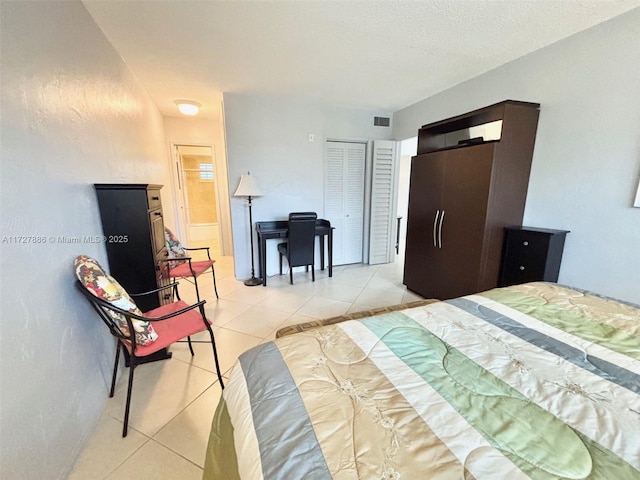 bedroom with light tile patterned floors, a closet, and a textured ceiling