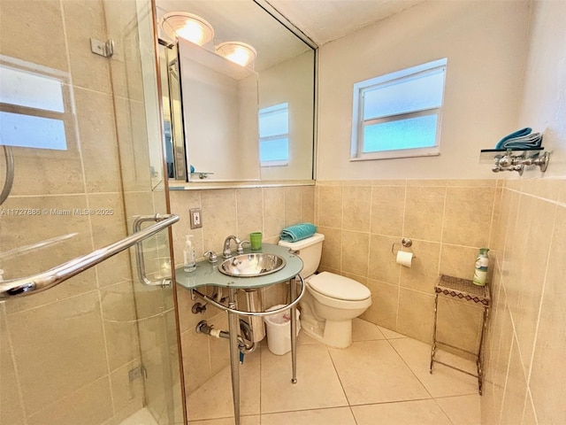 bathroom featuring toilet, tile walls, tile patterned floors, walk in shower, and sink