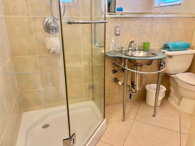 bathroom with walk in shower, toilet, tile walls, tile patterned flooring, and tasteful backsplash