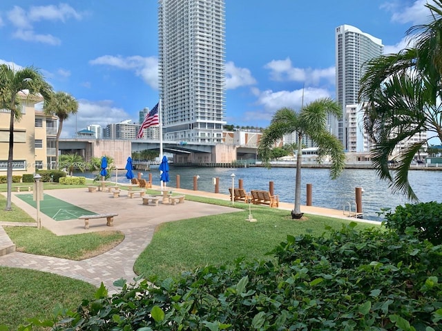 surrounding community featuring a water view and a lawn