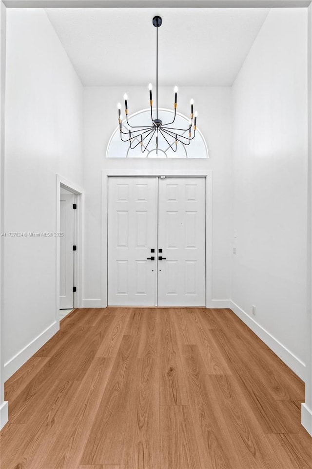 entryway featuring hardwood / wood-style flooring and a notable chandelier