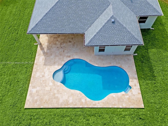 view of pool featuring a lawn