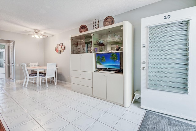 kitchen with ceiling fan and a textured ceiling