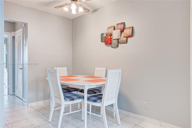 dining space featuring a textured ceiling, ceiling fan, and light tile patterned floors