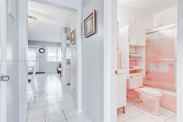 bathroom featuring tile patterned floors, enclosed tub / shower combo, toilet, and a textured ceiling