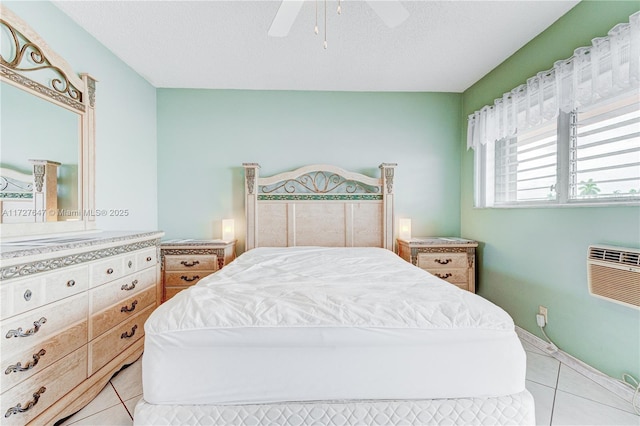 bedroom with ceiling fan, light tile patterned floors, and a textured ceiling