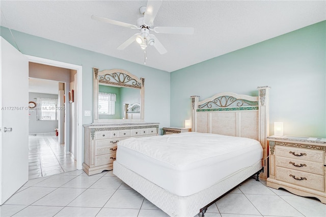 bedroom featuring ceiling fan, a textured ceiling, and light tile patterned flooring