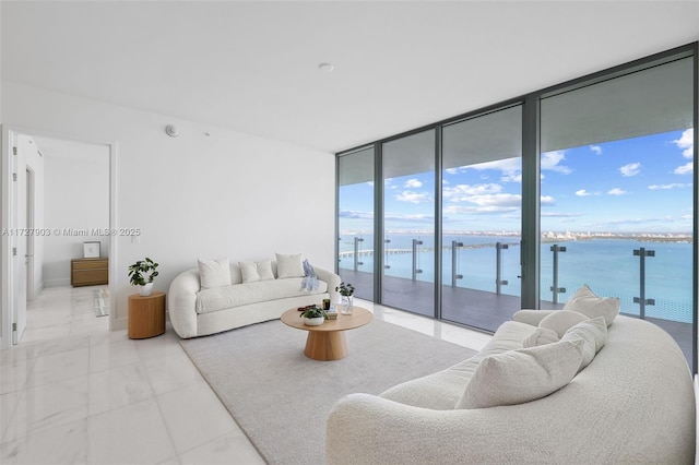 living room featuring floor to ceiling windows and a water view