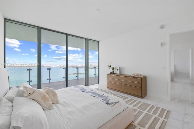 bedroom with a water view, access to exterior, and floor to ceiling windows