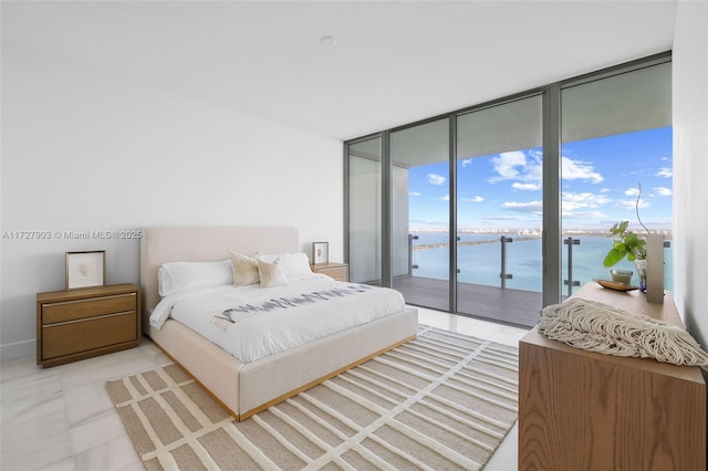 bedroom featuring a water view, a wall of windows, and access to outside