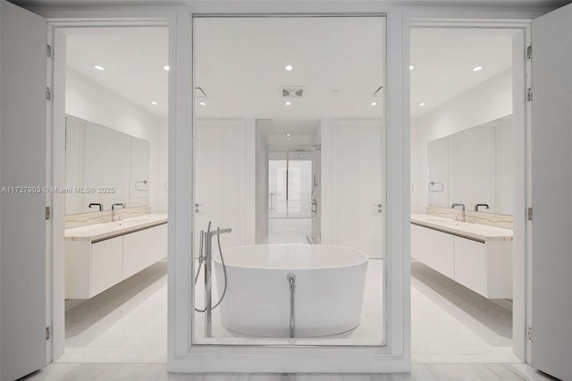 bathroom with a washtub and vanity