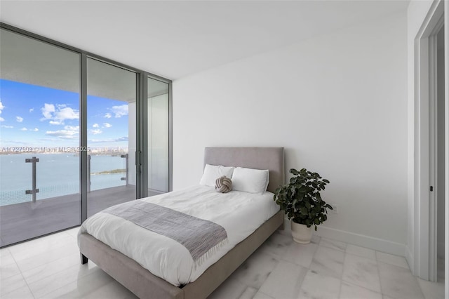 bedroom featuring a water view, access to exterior, and floor to ceiling windows