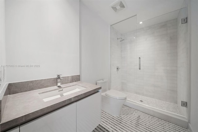 bathroom with toilet, tile patterned flooring, a shower with shower door, and vanity