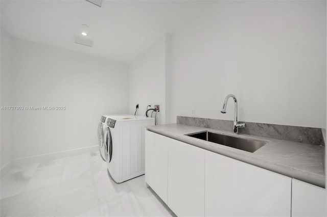 washroom with cabinets, sink, and independent washer and dryer