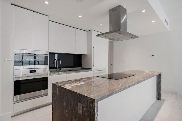 kitchen with white cabinets, island range hood, a center island, and sink