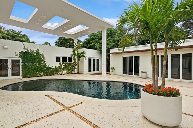 view of pool with french doors and a patio