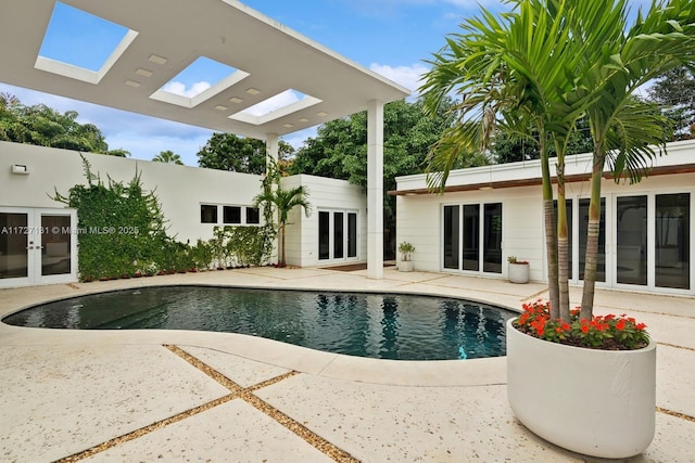 outdoor pool featuring french doors and a patio area