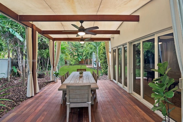 deck featuring ceiling fan, outdoor dining area, a lawn, and a fenced backyard