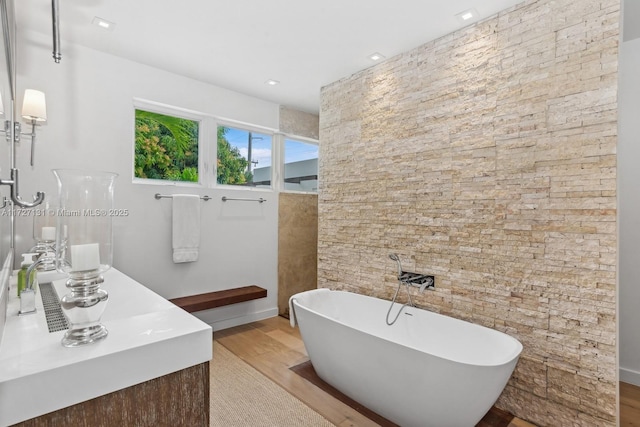 bathroom featuring vanity, hardwood / wood-style floors, and a bathtub