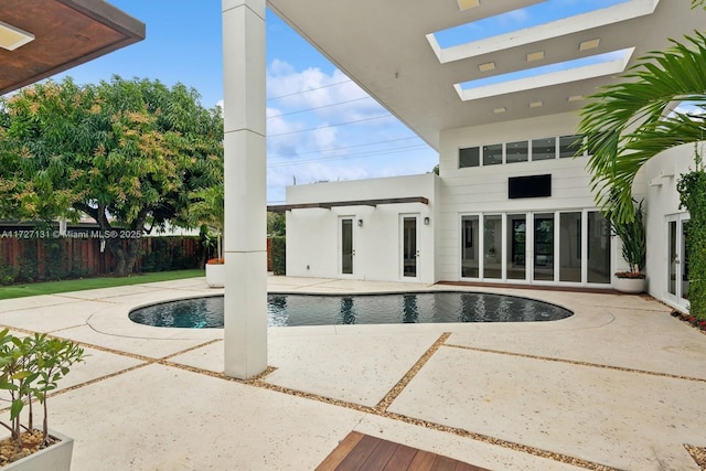 view of swimming pool with french doors, a patio, a fenced in pool, and fence