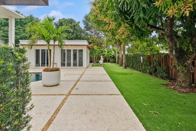 view of yard with a patio, an outbuilding, and fence