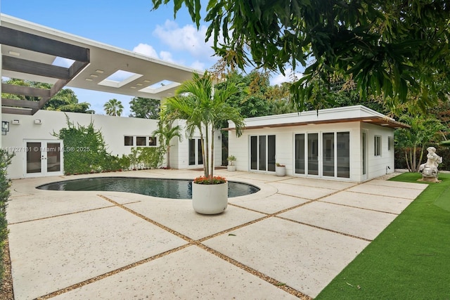 rear view of property featuring an outdoor pool, a patio, french doors, and a pergola