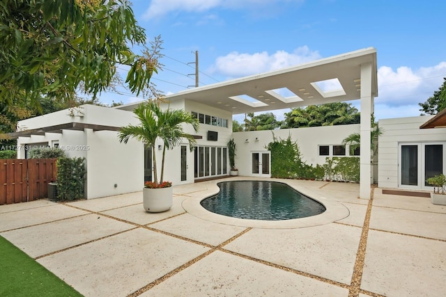 view of swimming pool featuring central air condition unit, fence, french doors, and a patio area