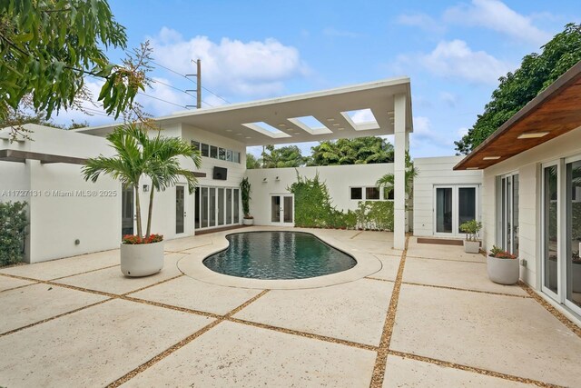 view of pool with french doors and a patio area