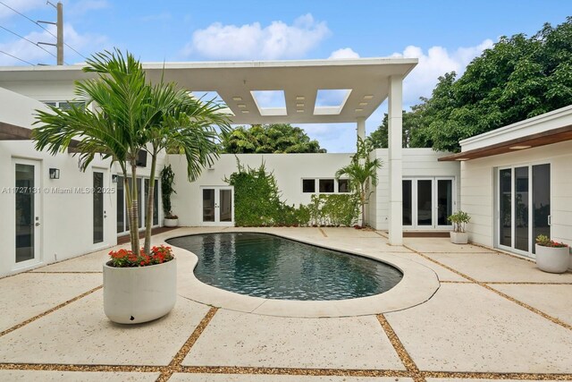 outdoor pool featuring french doors and a patio area