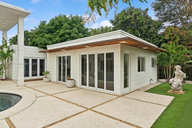 view of swimming pool featuring french doors and a patio area