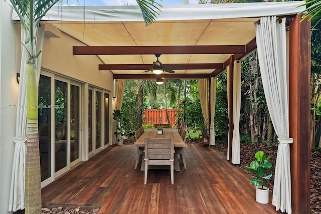 wooden deck featuring outdoor dining area, a ceiling fan, and fence