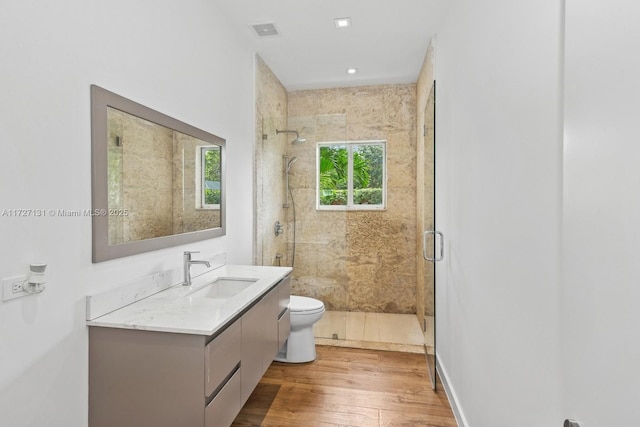 bathroom featuring visible vents, a stall shower, toilet, and wood finished floors